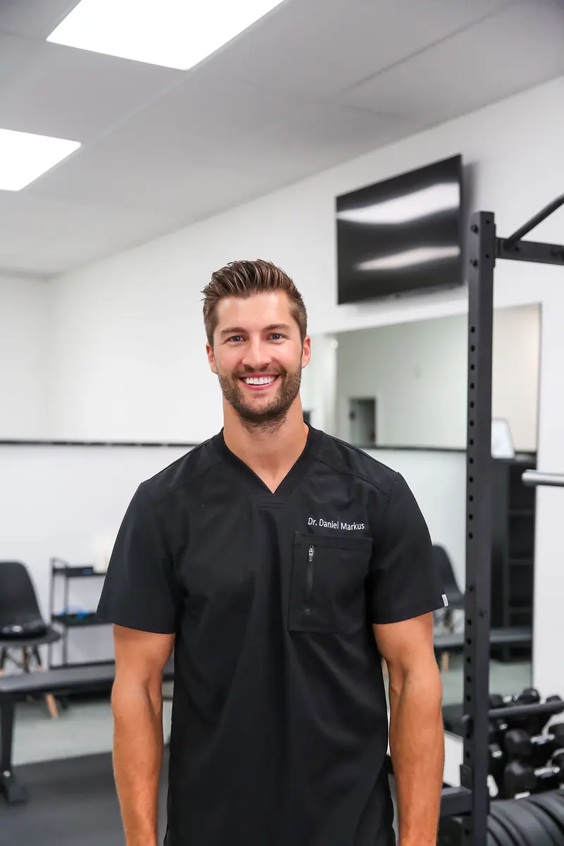 Dr. Daniel Markus performing postural assessment in Tempe chiropractic clinic